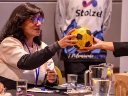 Participante recibiendo una pelota durante una dinámica en el salón.