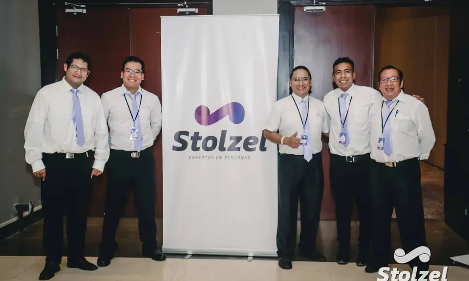 Equipo de Stolzel reunido junto al banner institucional de la empresa.