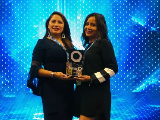 Dos representantes de Stolzel con el galardón del Latin American Quality Institute en el escenario del Bolivia Quality Summit 2021.